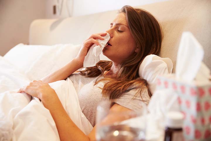 Woman suffering from cold lying in bed - how to obtain a fit note